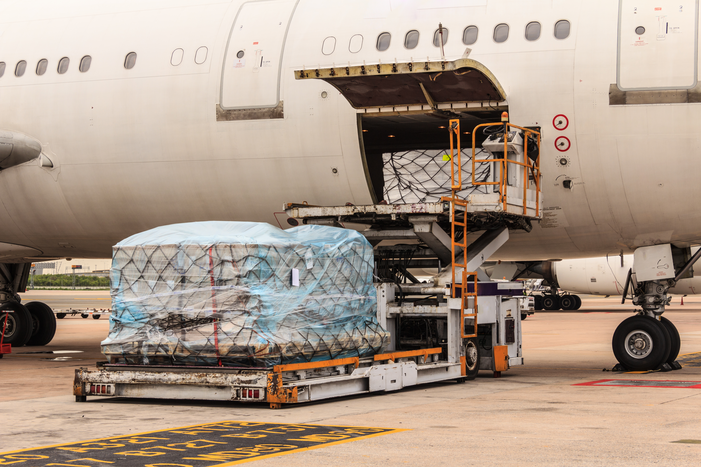 Airplane loaded with cargo containers taking off from a runway.
